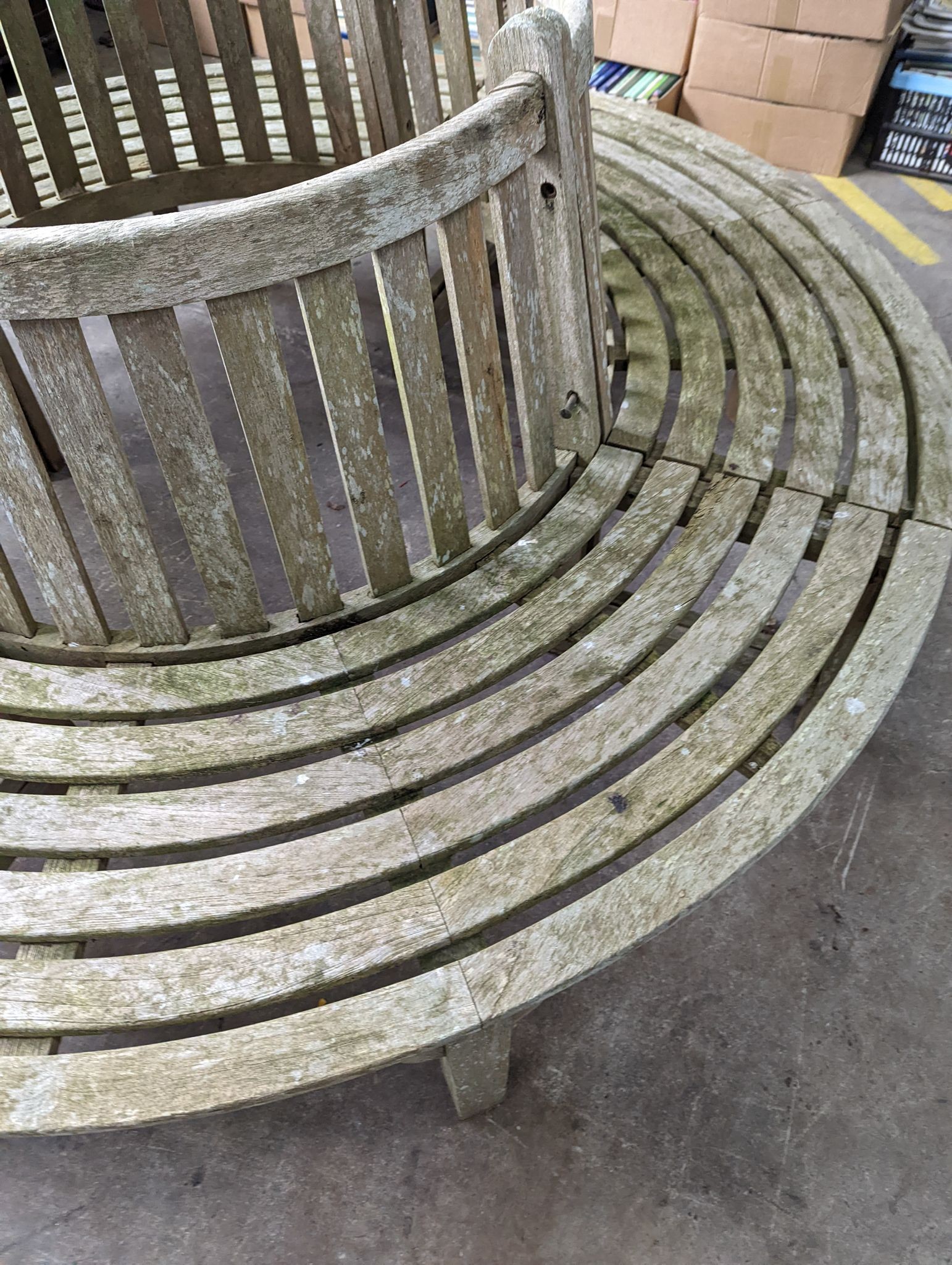A weathered teak four section tree seat, aperture 90cm diameter, the seat 200cm diameter, height 90cm